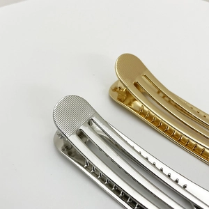 Close-up of gold and silver alloy metal hair clips with textured stripe and hollow design