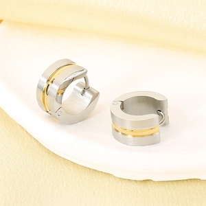 Macro shot of two-tone stainless steel hoop earrings with silver brushed edges and gold center
