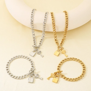 Vue détaillée de chaînes cubaines or et argent avec pendentifs clé et cadenas et fermoirs OT