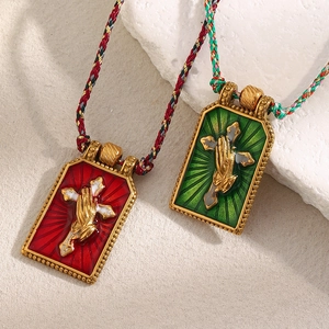 Detail of 18K gold plated cross and praying hand pendants with colorful woven rope