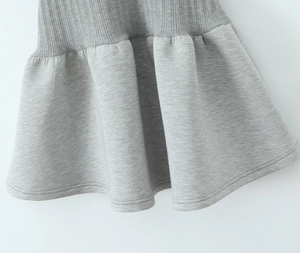 Détail de la robe polo grise avec taille en tricot côtelé et tissu plissé lisse