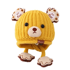 Cute yellow knit bear winter hat for kids featuring ear flaps and paw print tassels