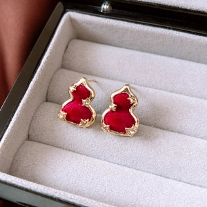 Detailed macro view of red flocked gourd earrings with golden edges and tiny rhinestones