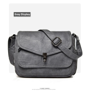 Close-up of vintage grey soft leather handbag with flap and black chrome metal buckle detail