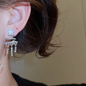 Close-up of elegant silver Christmas tree earrings with crystals worn by a model