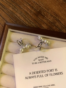 Detailed view of silver zircon pearl ear cuffs in a white jewelry gift box
