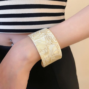 Detailed close-up of wide acrylic resin cuff bracelet with marbled texture on wrist