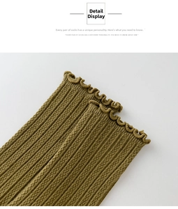 Detail view of mustard yellow knit socks featuring ruffle trim and vertical ribbed texture