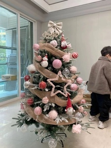 Detail of a Christmas tree decorated with gold mesh ribbons and colorful ball ornaments