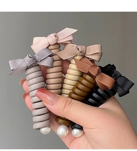 Détail d'élastiques spirales pour cheveux avec nœuds en satin et perles en cinq couleurs