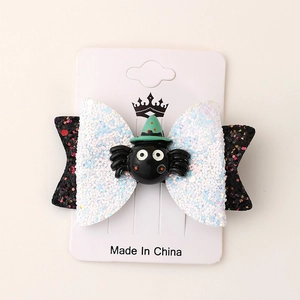 Detail of Halloween bow hair clip featuring a glittery black spider with a green wizard hat