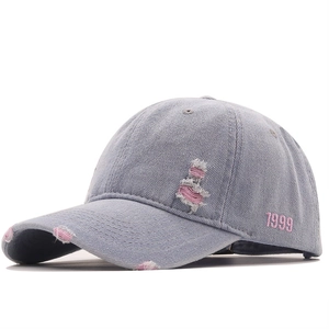 Distressed denim baseball cap with pink 1999 embroidery and vintage wash details