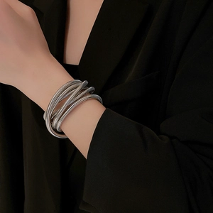 Detailed view of silver multi-layer wrap bracelet with polished metallic texture on wrist