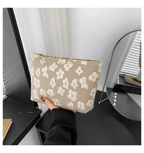Bolso de maquillaje beige con flores 3D blancas y cremallera dorada de calidad