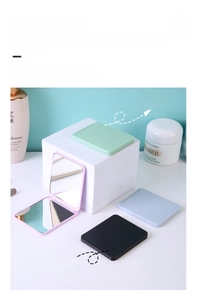 Macro shot of portable folding makeup mirrors in pastel colors on a white display block