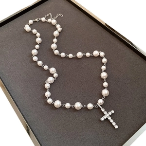 Collier élégant en perles avec croix sertie de strass brillants sur une chaîne argentée