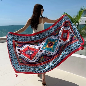 Ethnic print bohemian shawl scarf displayed by a model at a sunny seaside beach resort