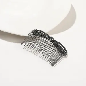Detail of elegant black hair comb featuring a butterfly bow set with sparkling black rhinestones