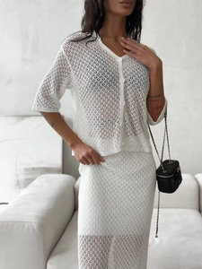 Detail of white hollow crochet knit texture on two-piece cardigan and skirt set