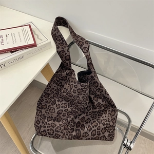 Macro detail of leopard print tote bag fabric showing suede texture and wide strap design