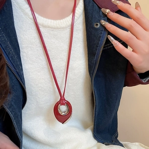 Detailed view of red teardrop leather necklace pendant with silver metal ring