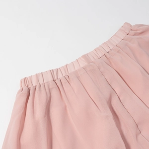 Detail of pink chiffon fabric featuring elastic smocked waist and soft ruffled texture