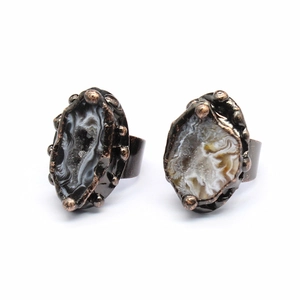 Macro shot of two vintage natural agate geode rings with unique druzy stone textures