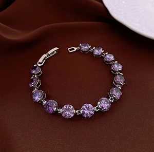 Detailed macro view of purple zircon bracelet with silver clasp on velvet background