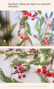 Macro detail of artificial pine garland with red berries and warm LED fairy lights
