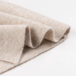 Macro shot of soft oatmeal knit fabric texture showing premium fibers and warm material