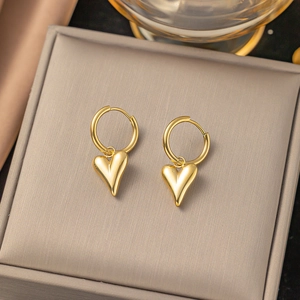Elegant gold heart pendant hoop earrings displayed on premium jewelry padding