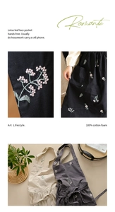 Detailed close-up of floral embroidery on cotton apron with ruffle lace and pockets