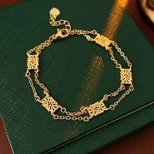 Detail of vintage gold-tone floral bracelet with double chains and heart pendant