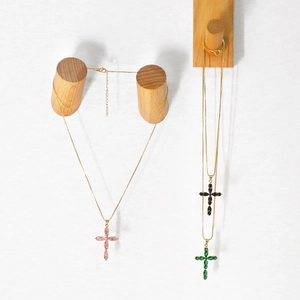 Detail of colorful cross necklaces in pink, black, and green marquise crystals