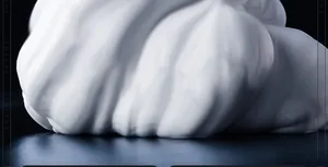 Macro view of creamy sandalwood shaving foam texture on a dark background