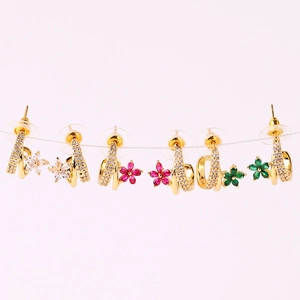 Detailed view of three pairs of gold-plated C-shaped earrings with colorful flower zircons