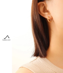 Close-up of 18K gold plated stainless steel hoop earring with vintage twisted texture