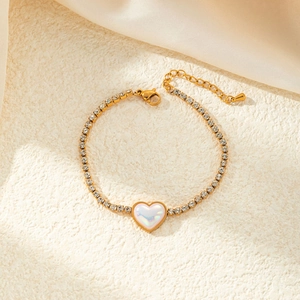 Elegant gold-tone titanium bracelet with a pearly heart pendant and sparkling rhinestones