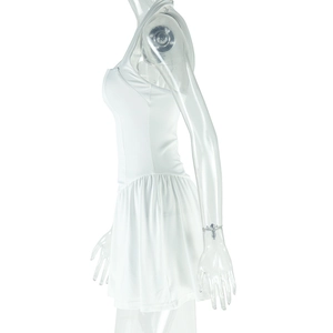 Détail de la robe blanche sans manches montrant la texture de la jupe plissée