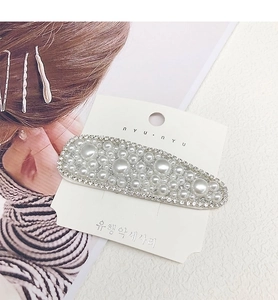 Detailed view of pearl and rhinestone hair clip set on a branded display card