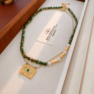 Dettaglio di una collana vintage a due strati con perle di bambù verdi e pendente