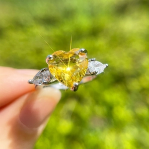 Sparkling yellow heart-cut cubic zirconia ring with side pear stones on a silver band