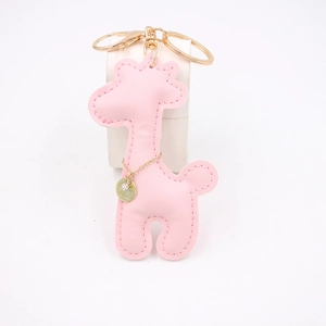 Detail of pink PU leather giraffe keychain with golden metal clasp and charm