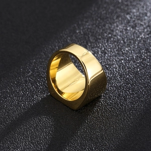 Vista macro di un anello a fascia larga placcato oro lucido su sfondo nero opaco