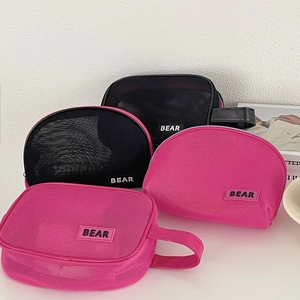 Detailed macro view of four mesh cosmetic bags with bear logo and durable zippers