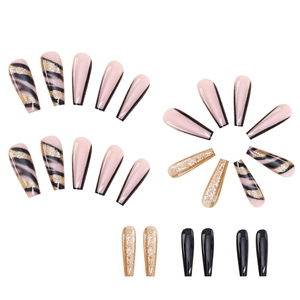 Detailed macro view of long coffin press-on nails in pink, gold glitter, and black styles