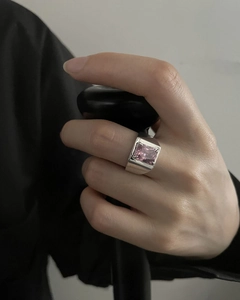 Close-up of a wide silver band ring featuring a large rectangular pink gemstone on hand
