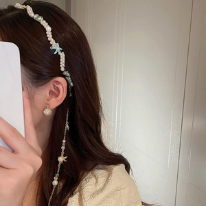 Close-up of pearl headband with blue starfish detail and matching pearl earrings