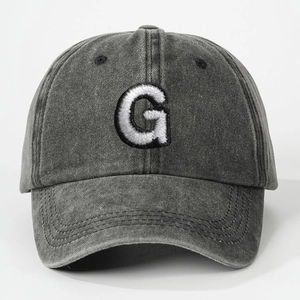 Detailed close-up of dark grey washed cotton baseball cap with white letter G embroidery