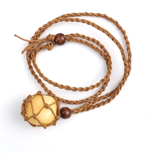 Handmade woven necklace with raw yellow crystal stone pendant in a brown net pouch